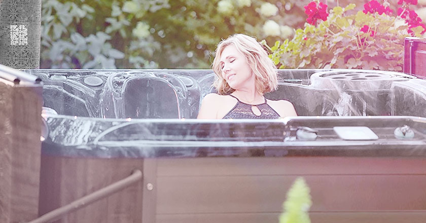 Woman enjoying her hot tub in her back yard